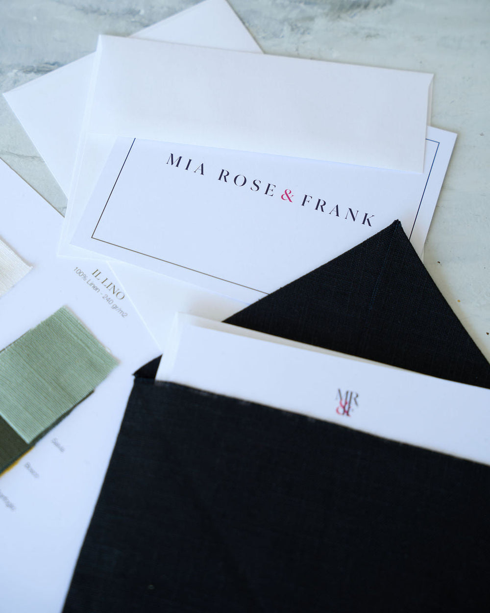 Stack of cards with 'Mia Rose & Frank' branding on a marble surface