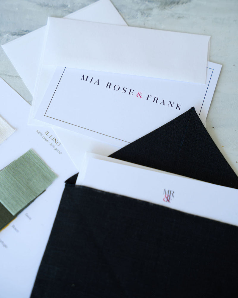 Stack of cards with 'Mia Rose & Frank' branding on a marble surface